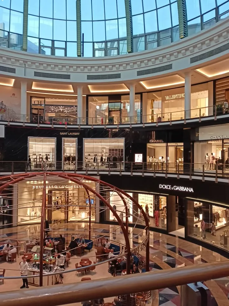 Luxury fashion boutiques on two levels under the glass dome of a shopping mall
