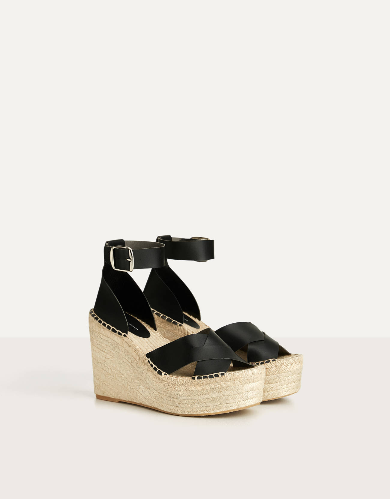 Black sandal. Jute-lined wedge. Closing by means of a bracelet with buckle.