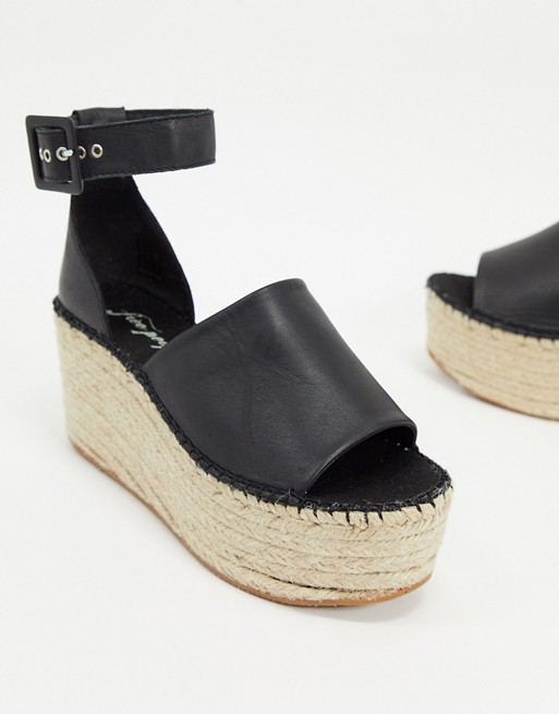 Black wedge sandals with an esparto grass platform.