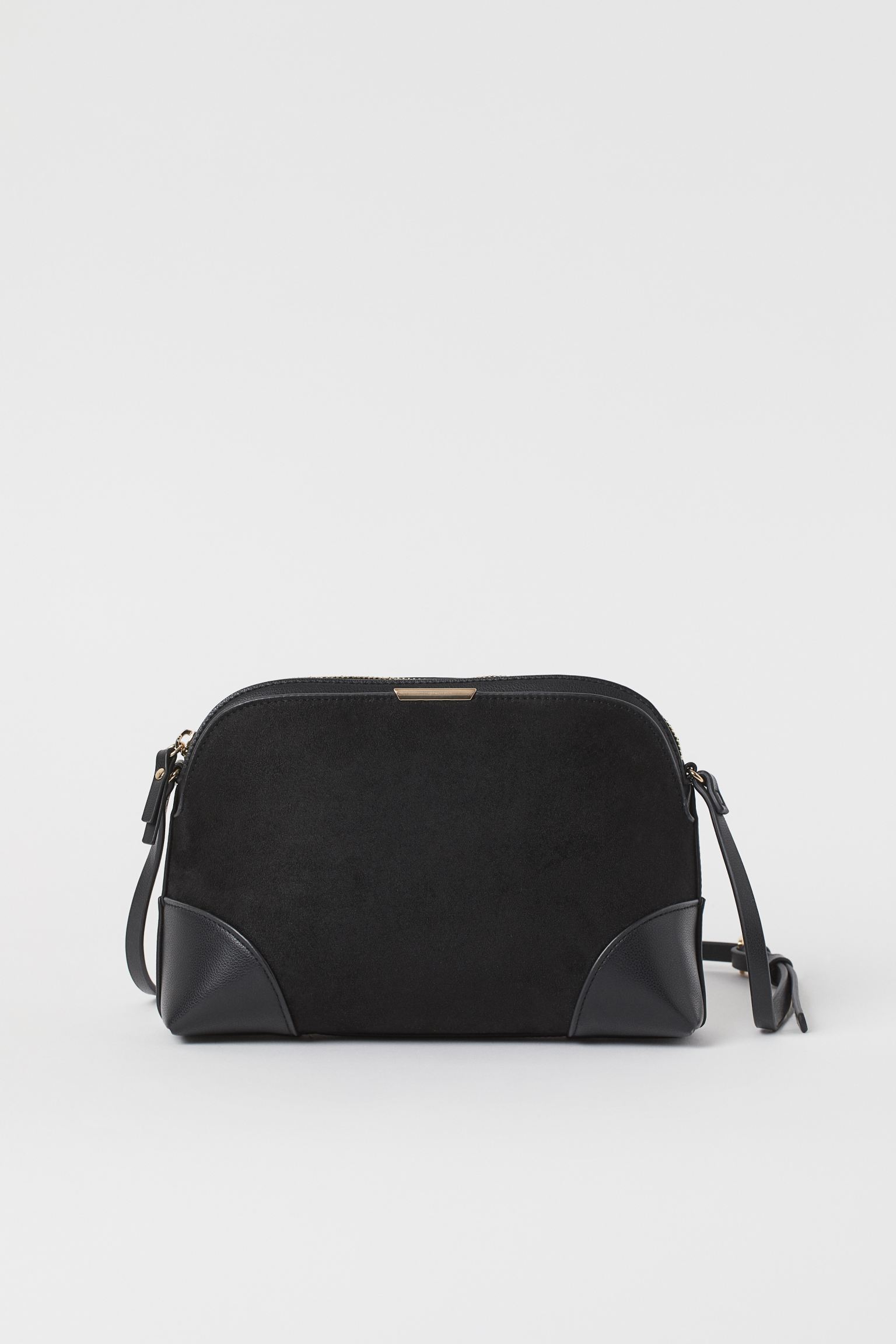 Small shoulder bag in synthetic leather and suede with zipper at the top and adjustable thin strap. An outer compartment with magnetic closure and an inner compartment with zipper.